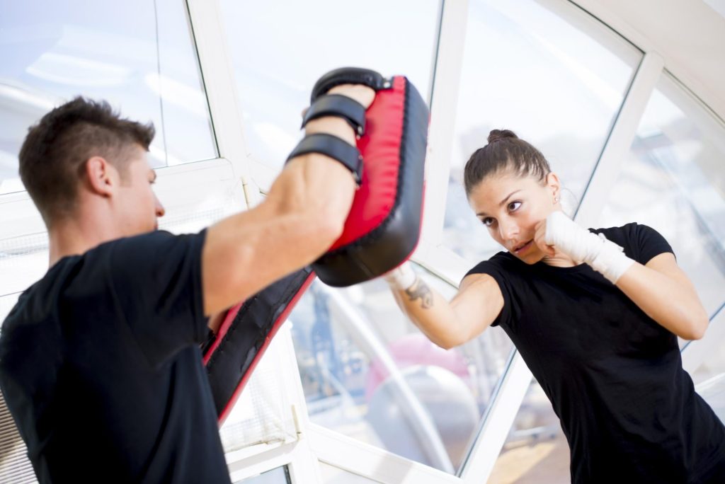 Girl playing boxing with her coach