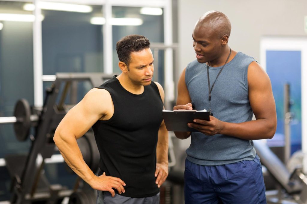 Man in the gym with his coach