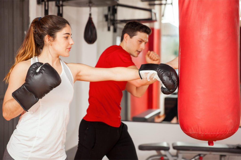 Girl practicing boxing at the gym with her coach